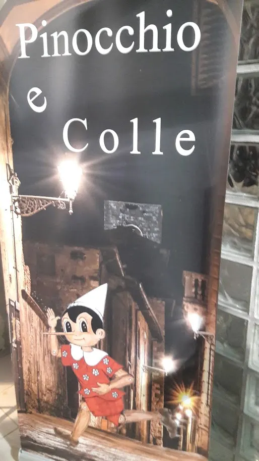 Pannello «Pinocchio e Colle»: il burattino disegnato in un vicolo di Colle Alta sotto un lampione in ferro battuto